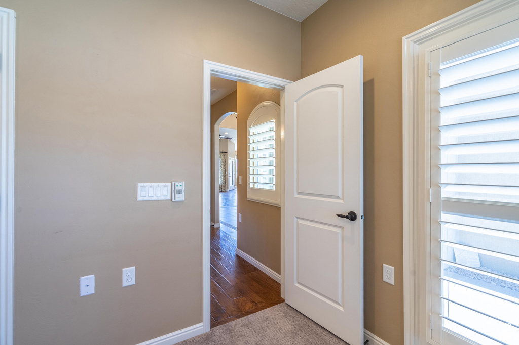 Hall featuring arched walkways and wood finished floors