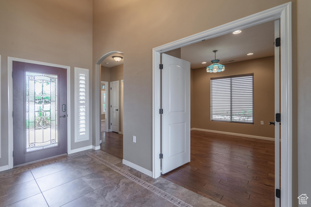 Foyer featuring arched walkways, a high ceiling, and recessed lighting