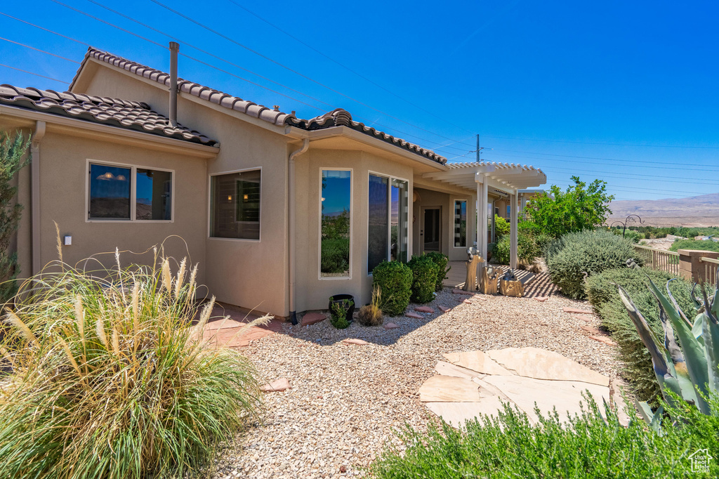 Back of property with stucco siding and a tiled roof