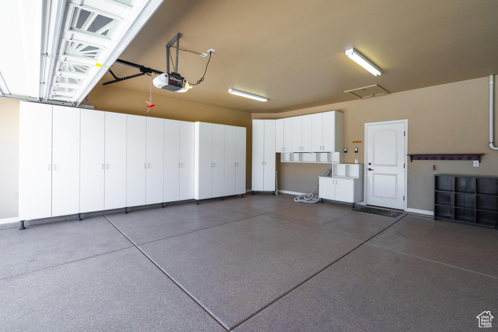 Garage with a garage door opener and baseboards