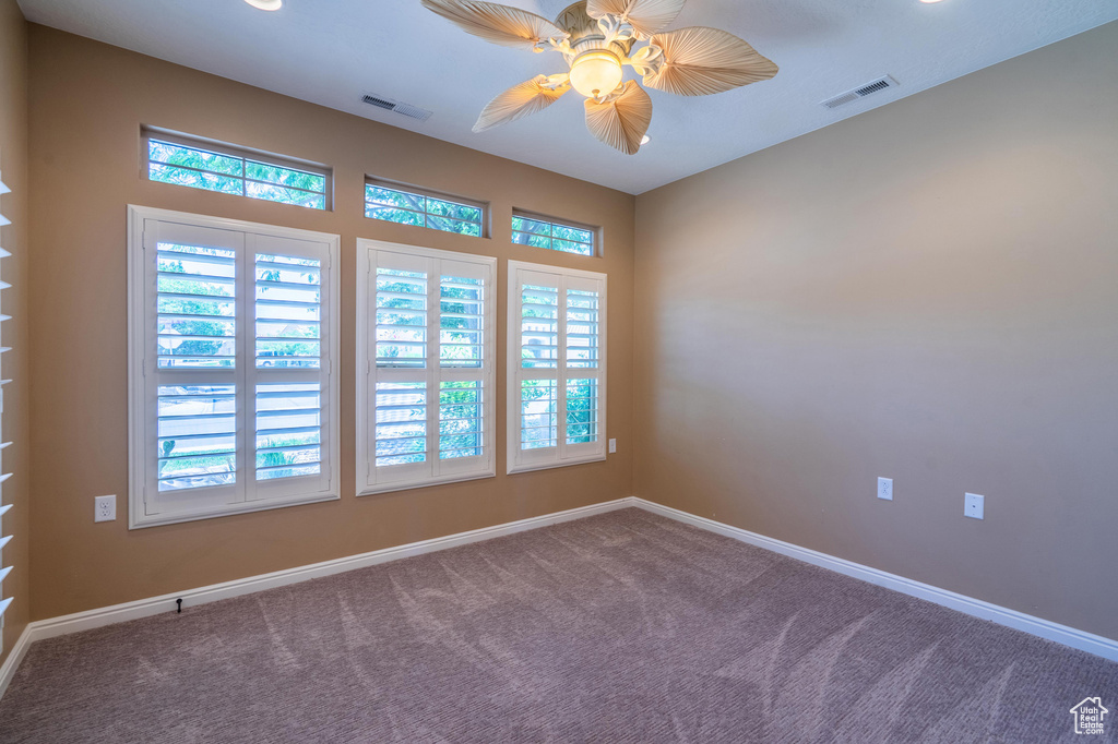 Unfurnished room featuring a ceiling fan and carpet flooring