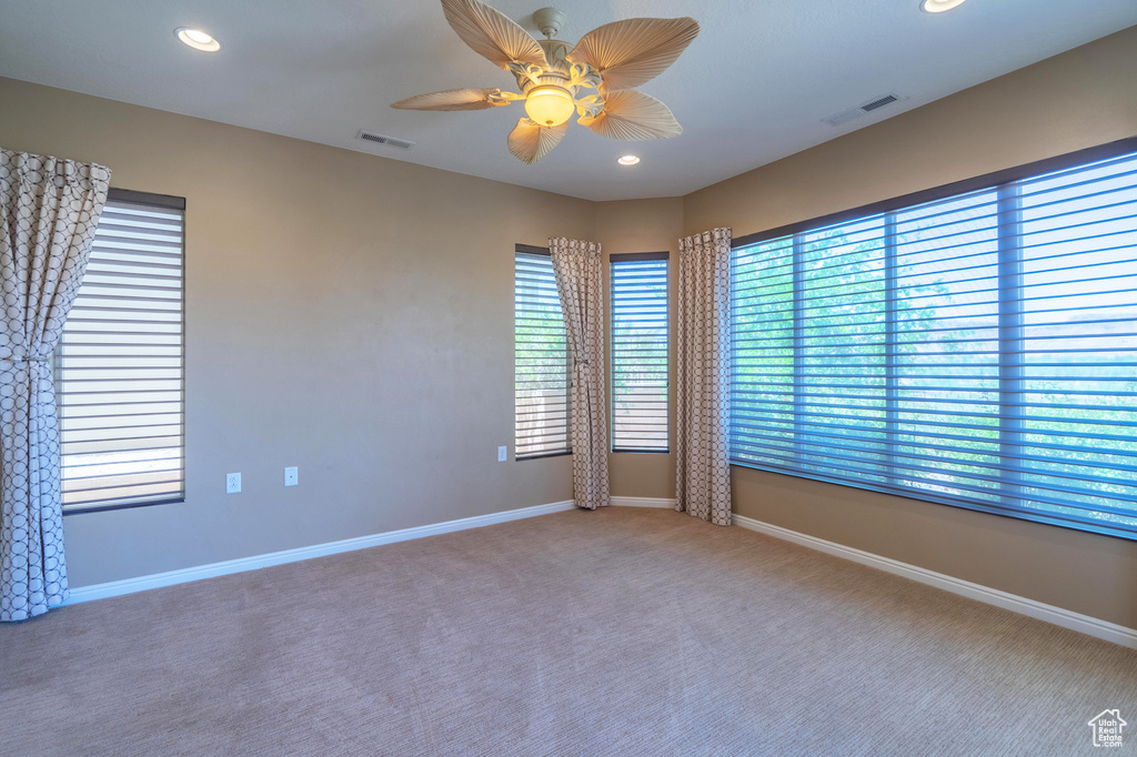 Spare room featuring carpet flooring, plenty of natural light, recessed lighting, and a ceiling fan