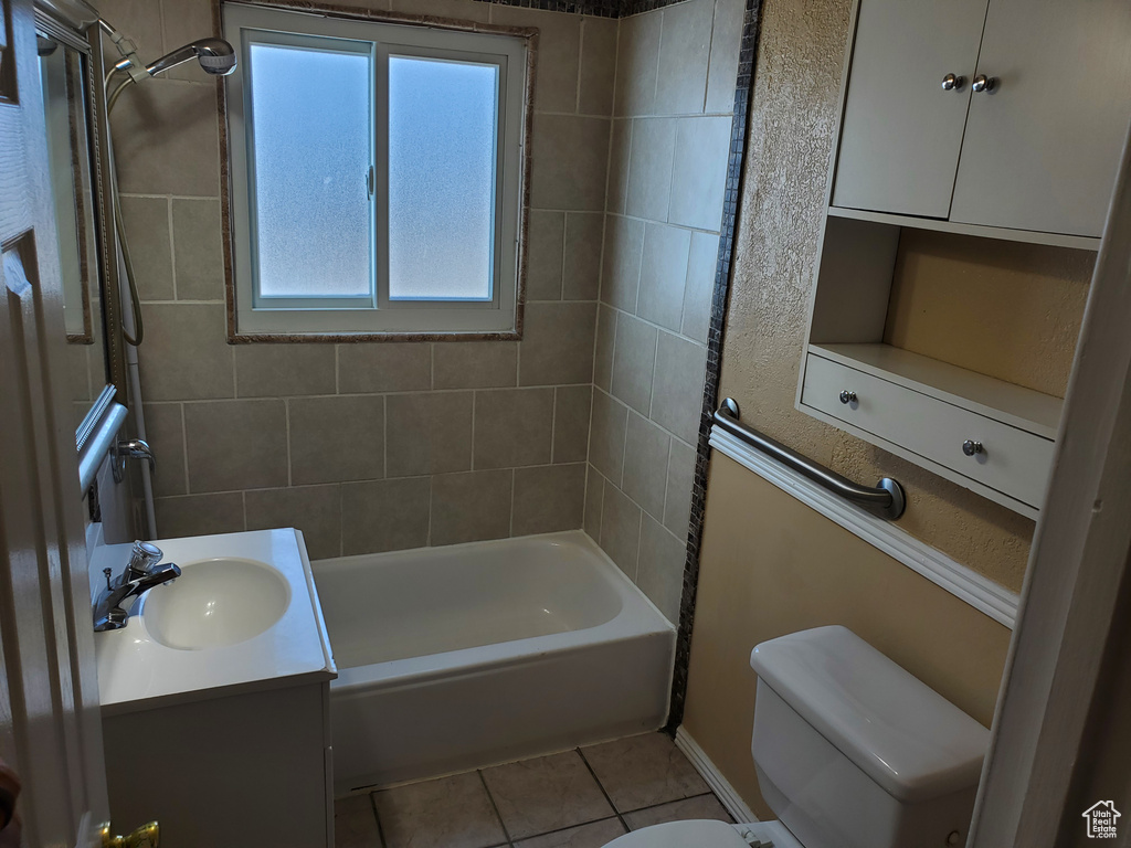 Bathroom with washtub / shower combination, tile patterned floors, and vanity