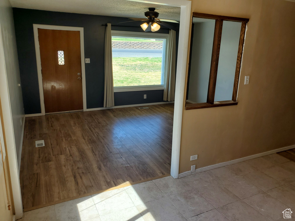 Entrance foyer with ceiling fan and wood finished floors