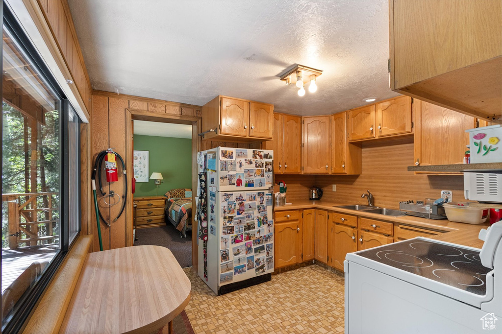 Kitchen featuring white appliances, light floors, light countertops, and a textured ceiling