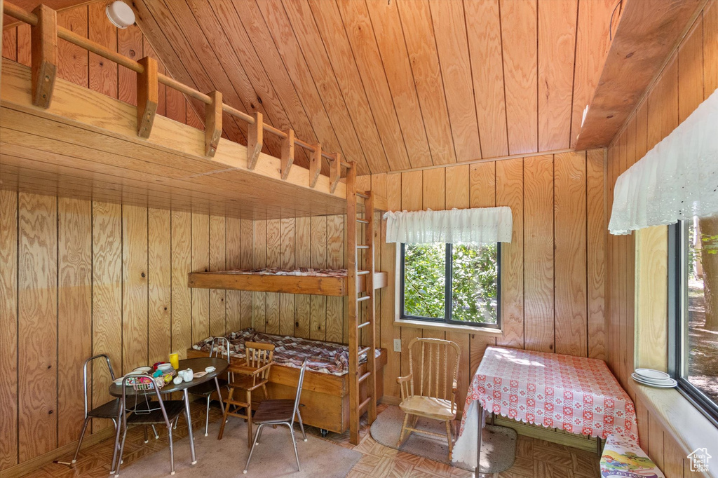 Bedroom featuring wood walls, wooden ceiling, and vaulted ceiling