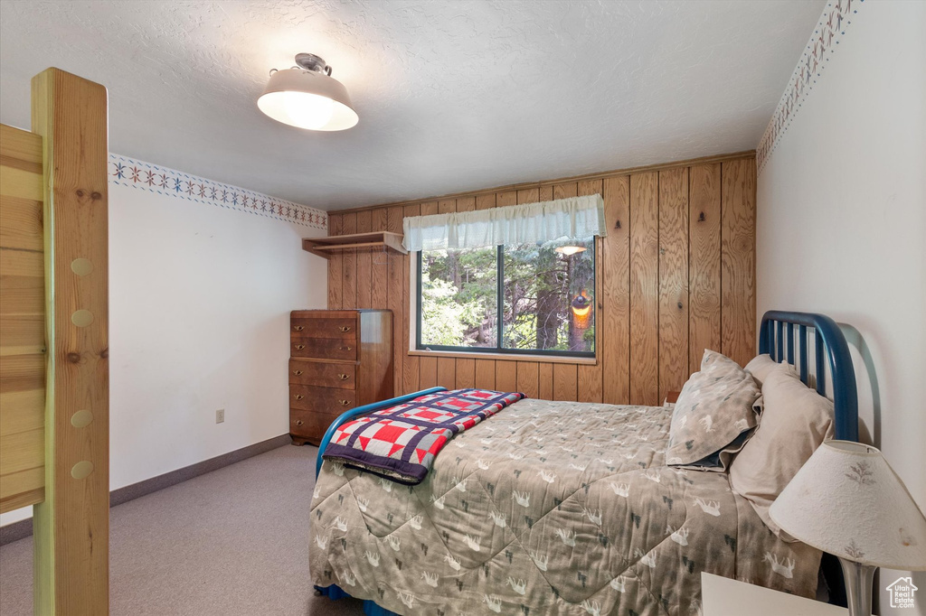 Bedroom with wooden walls and carpet