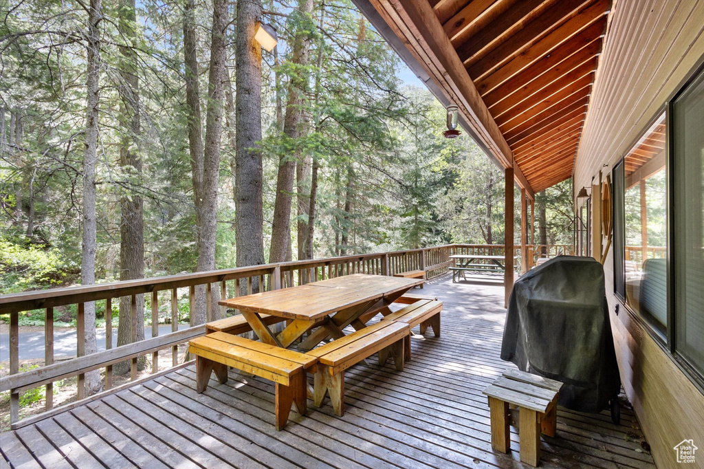 Wooden deck with outdoor dining space and area for grilling