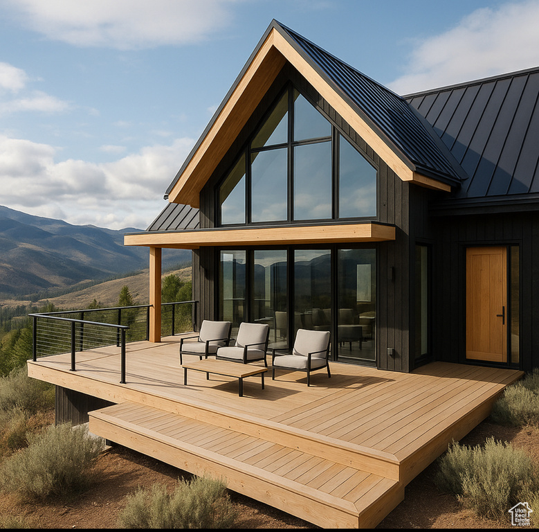 Rear view of property featuring a standing seam roof, a metal roof, and a deck with mountain view