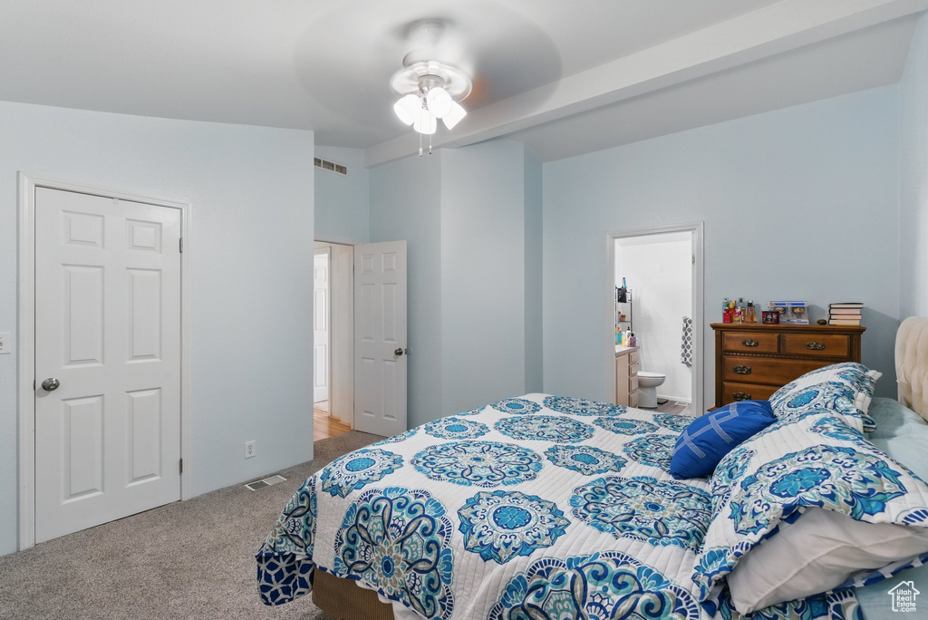 Carpeted bedroom with ensuite bathroom and a ceiling fan