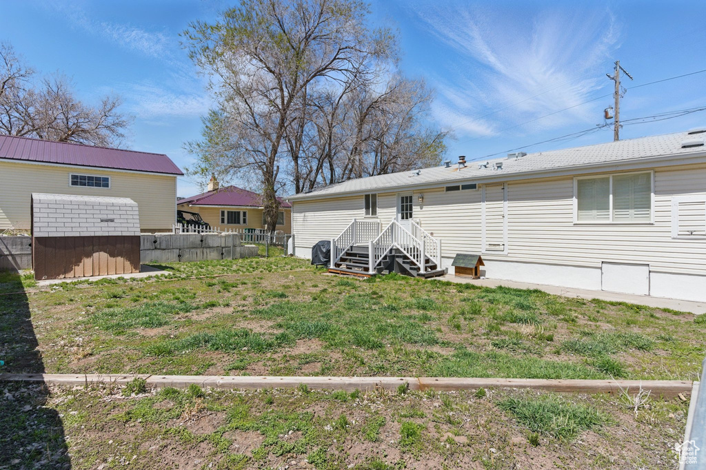 Rear view of house featuring a storage unit