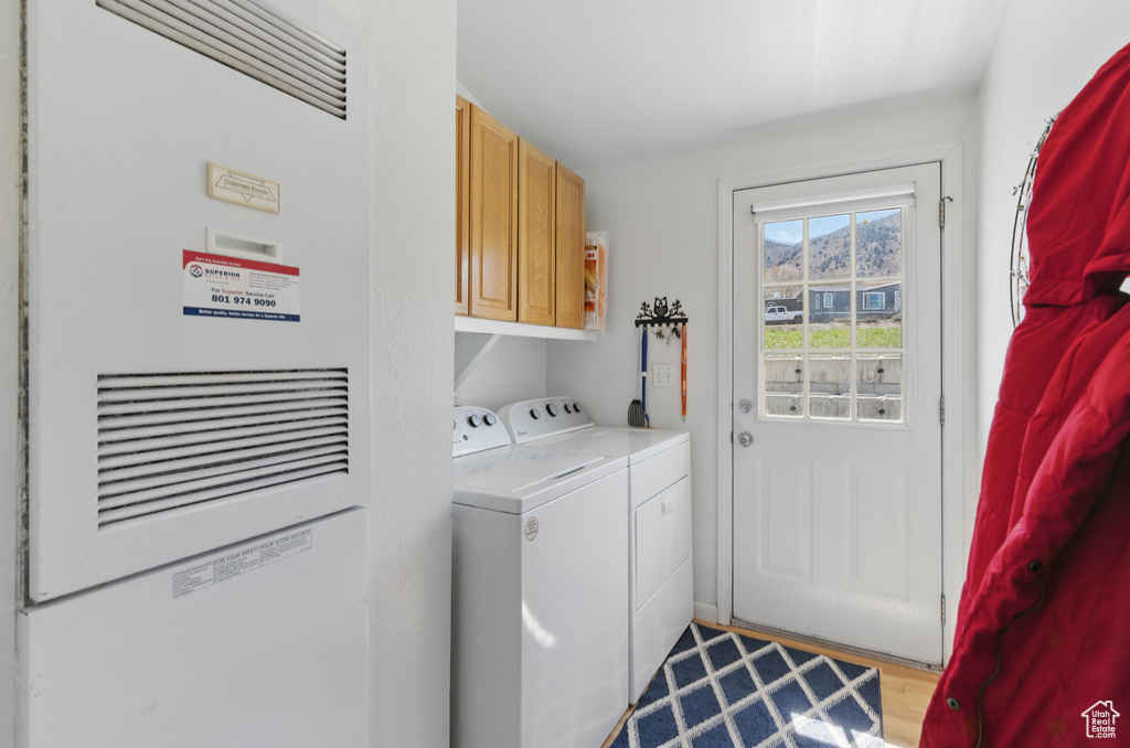 Washroom with washer and dryer, a heating unit, and cabinet space