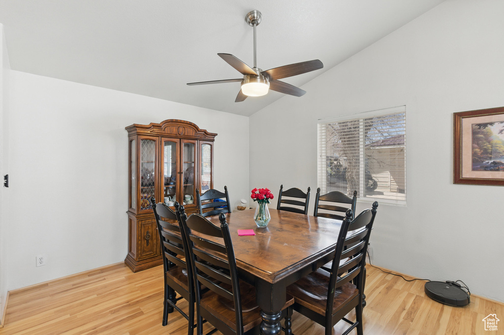 Dining area featuring vaulted ceiling, light wood-style flooring, and ceiling fan