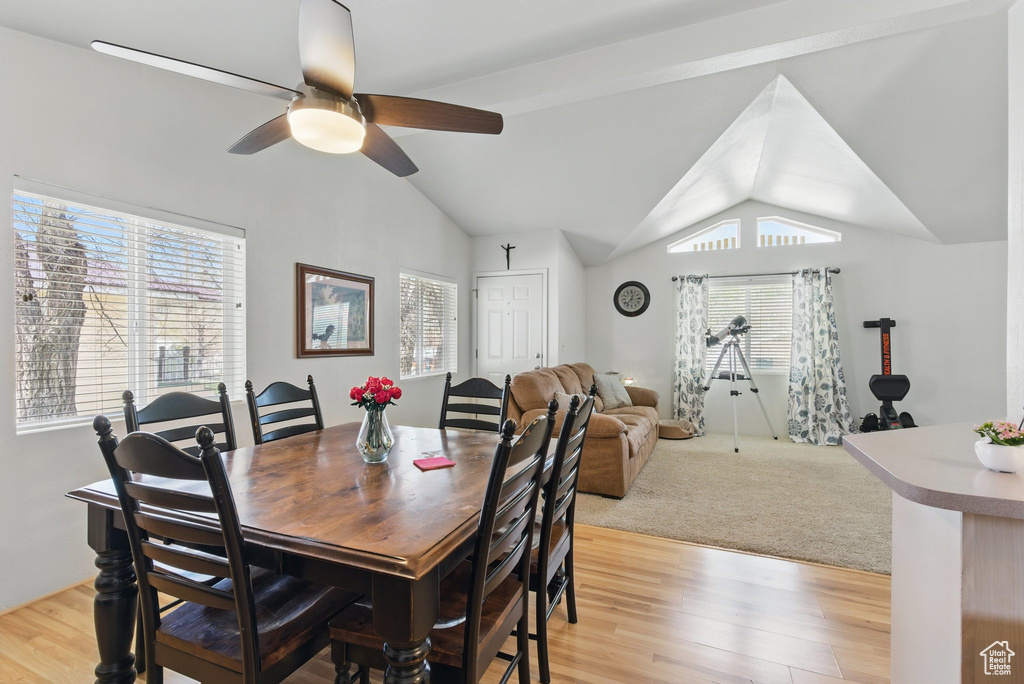 Dining space featuring ceiling fan, lofted ceiling, plenty of natural light, and light wood-type flooring