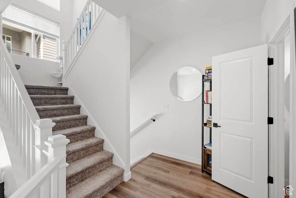 Stairs with wood finished floors and baseboards