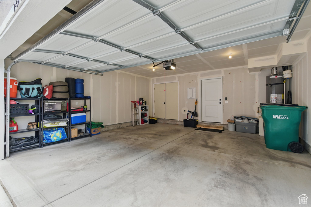 Garage featuring strapped water heater and a garage door opener