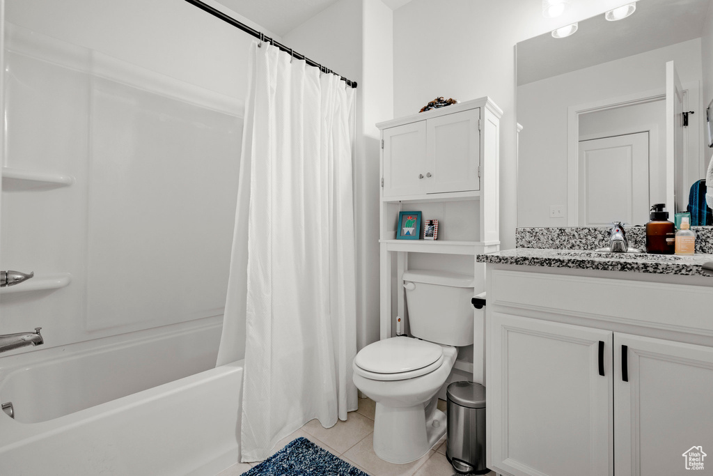 Full bathroom featuring vanity, shower / tub combo with curtain, and tile patterned flooring