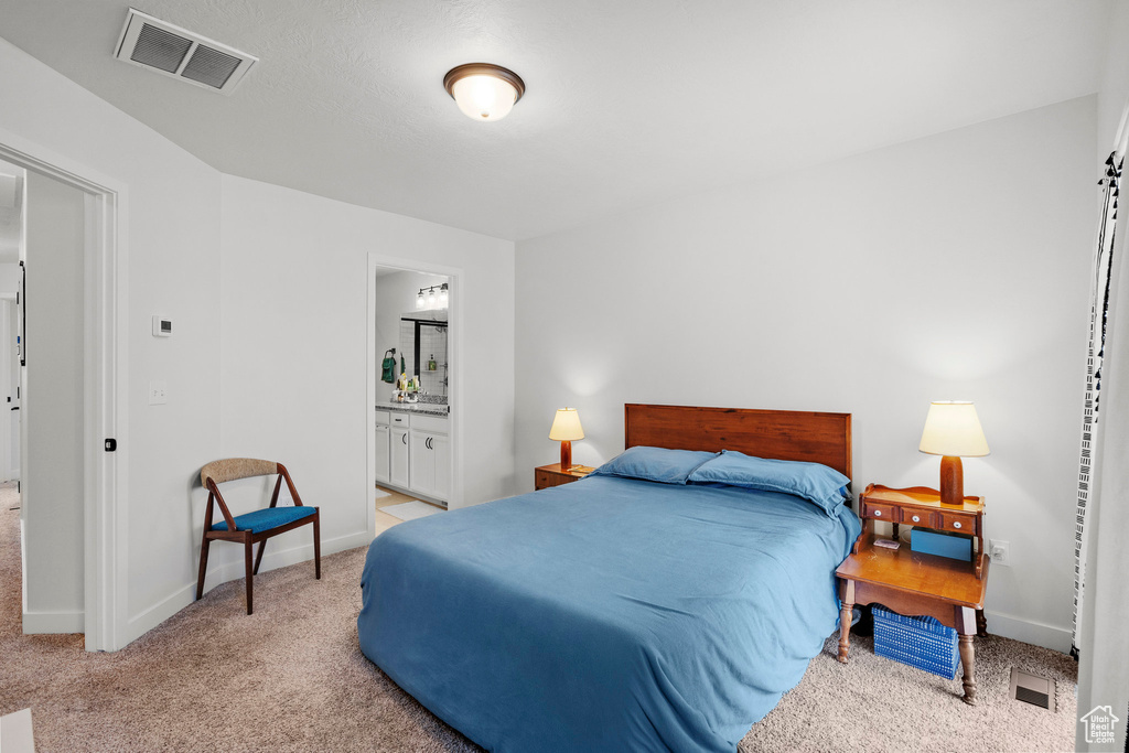 Bedroom with carpet flooring and ensuite bath