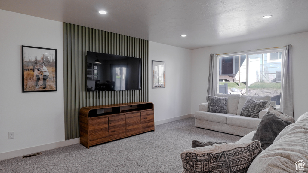 Carpeted living area with recessed lighting and baseboards