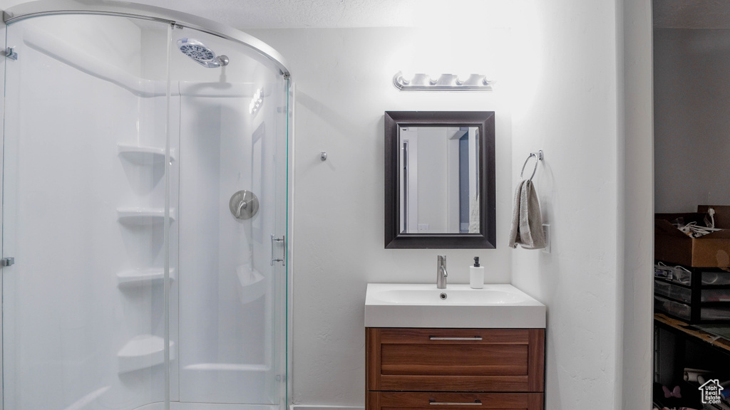 Bathroom featuring a shower stall and vanity