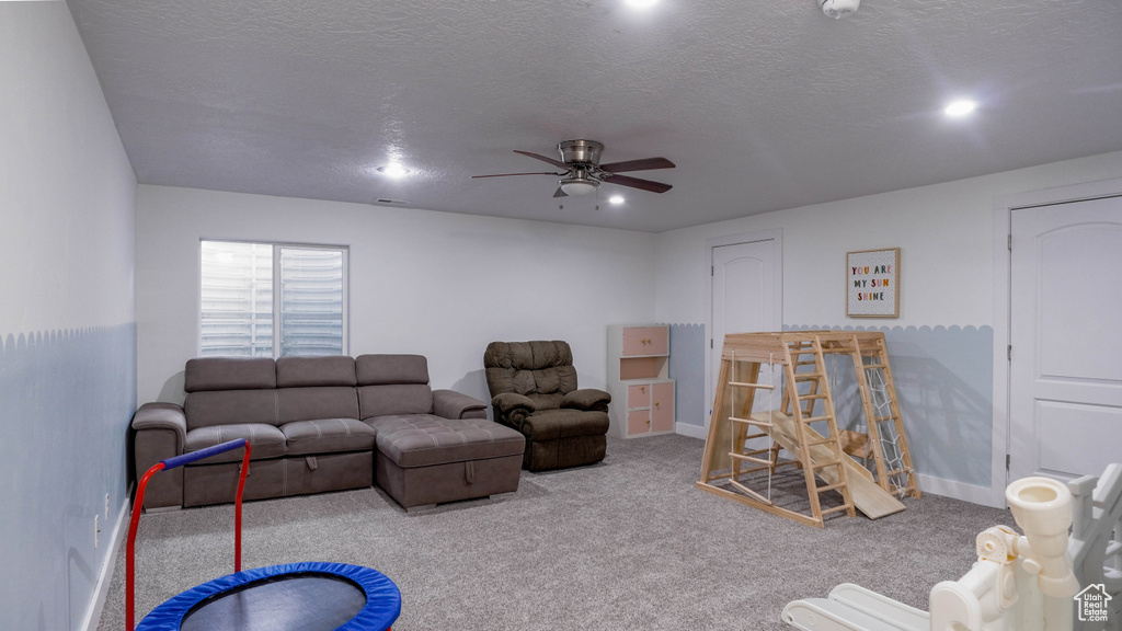 Living area featuring a ceiling fan, carpet flooring, recessed lighting, and a textured ceiling