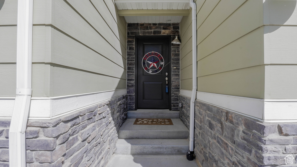 Doorway to property featuring stone siding