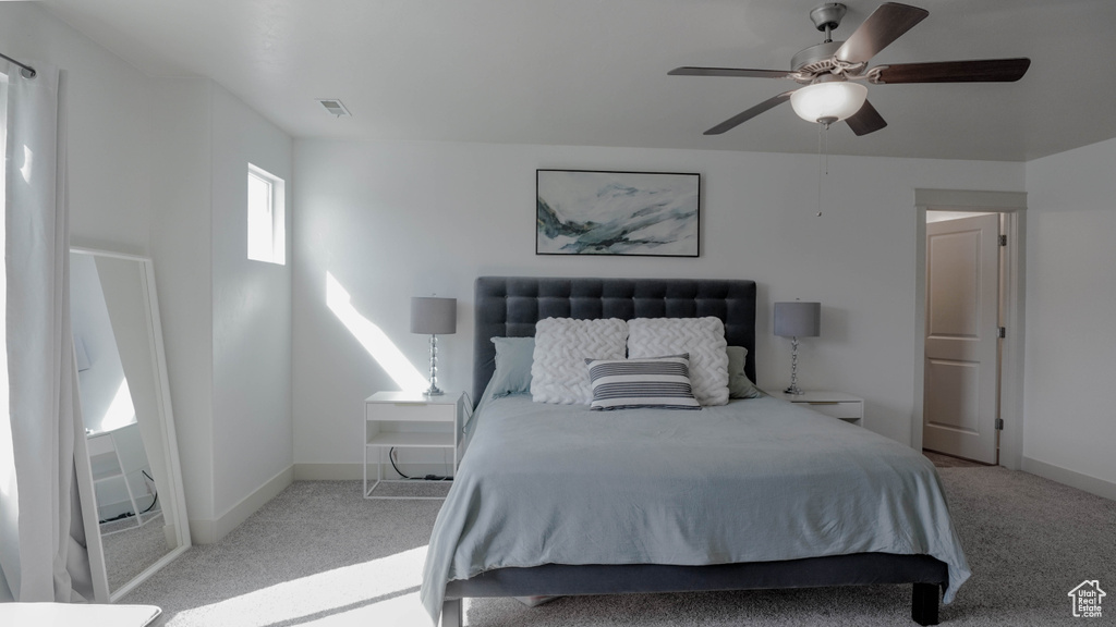 Carpeted bedroom featuring a ceiling fan and baseboards