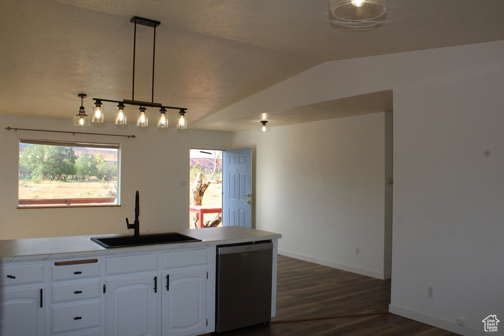 Kitchen with dishwasher, dark wood finished floors, white cabinetry, vaulted ceiling, and light countertops