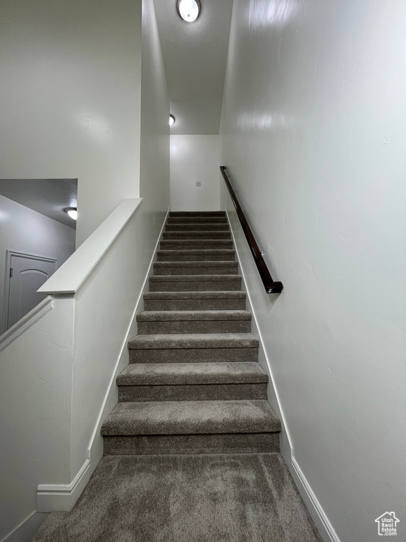 Stairway featuring baseboards and carpet floors