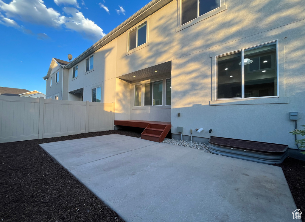 Back of house with stucco siding and a patio