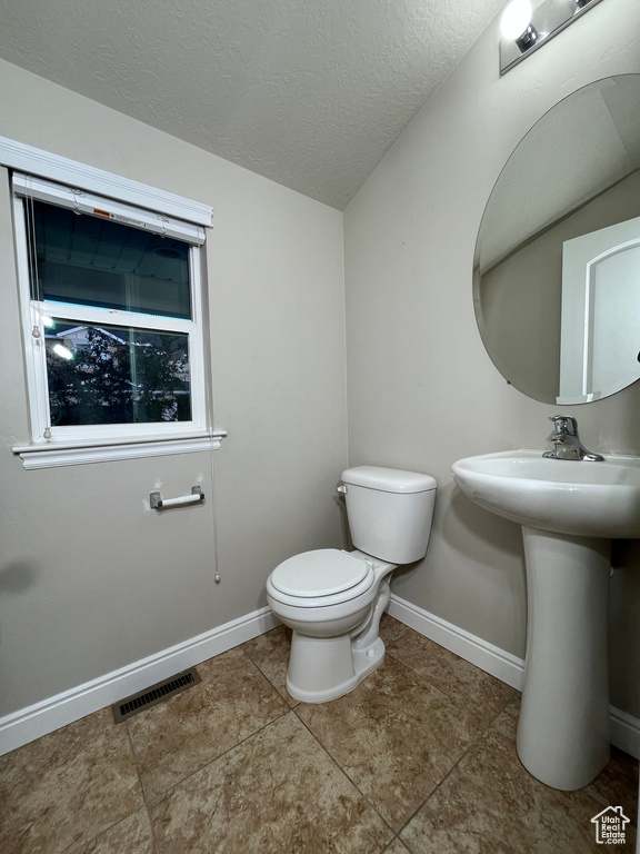Half bath featuring a textured ceiling and tile patterned floors