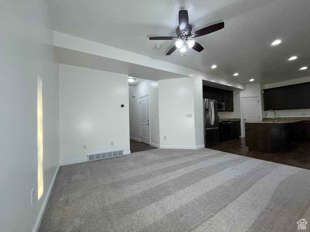 Unfurnished living room featuring dark colored carpet, recessed lighting, and a ceiling fan