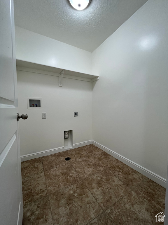 Laundry room featuring washer hookup, electric dryer hookup, and a textured ceiling