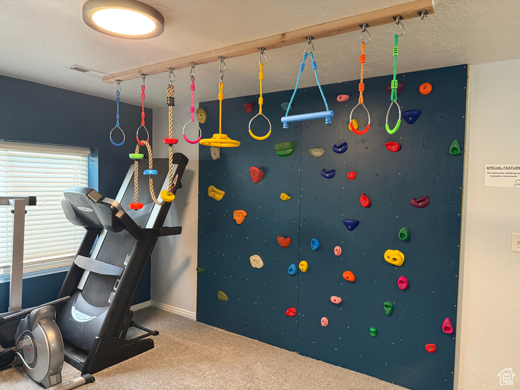 Exercise room featuring carpet and baseboards