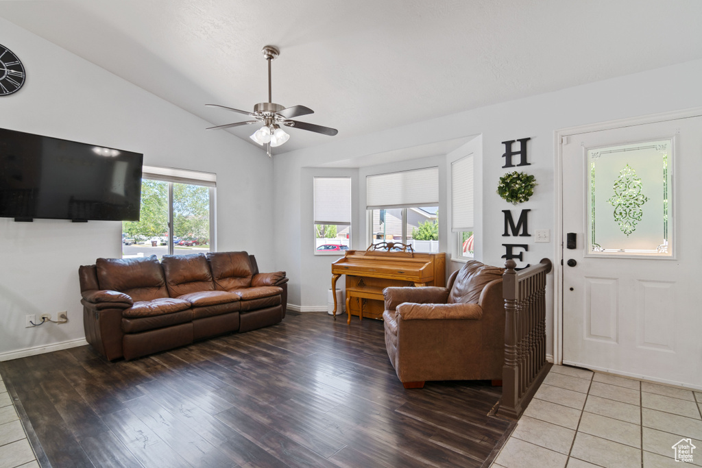 Living area with ceiling fan, vaulted ceiling, and light wood finished floors