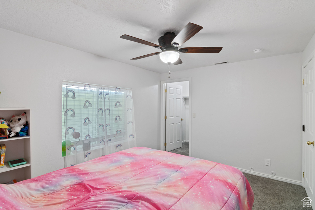 Carpeted bedroom featuring baseboards and ceiling fan