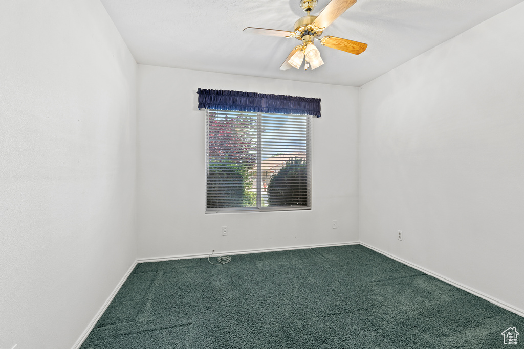 Empty room with carpet floors, baseboards, and ceiling fan