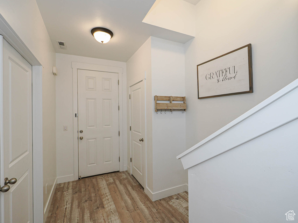 Foyer with light wood finished floors and baseboards