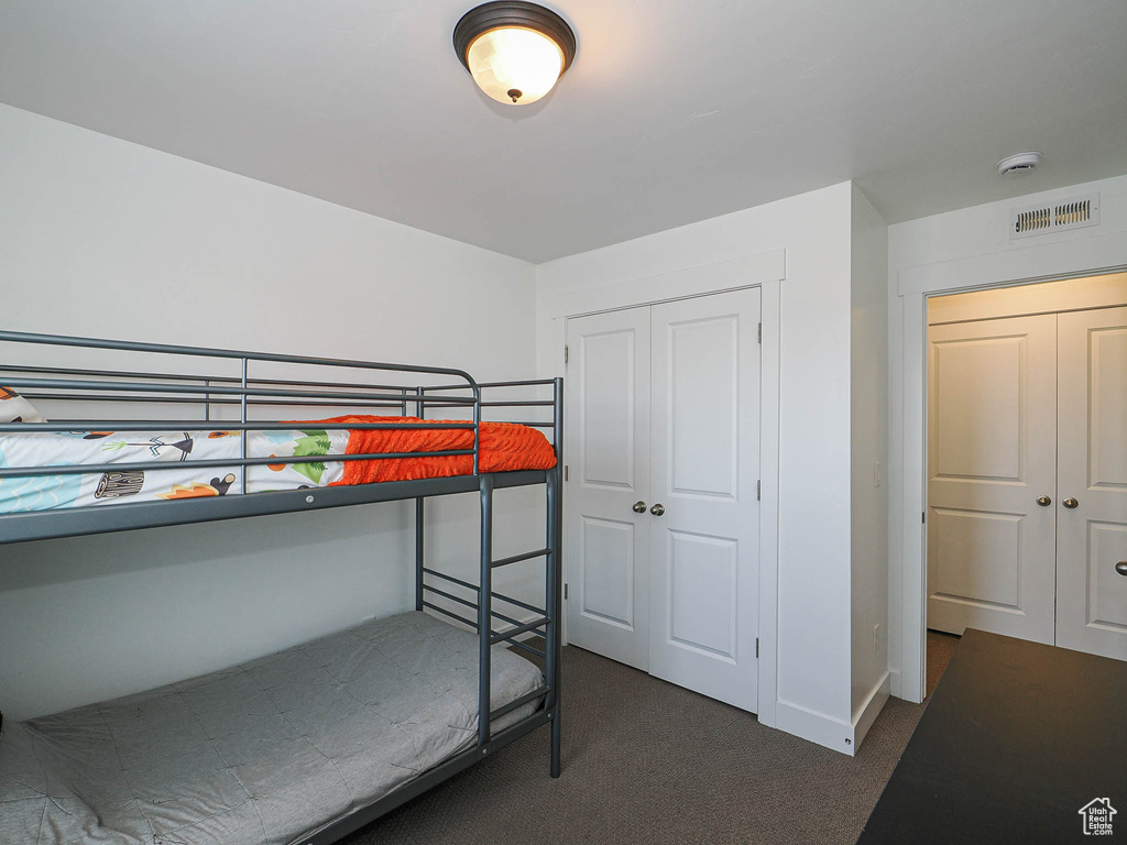 Bedroom with dark carpet and a closet