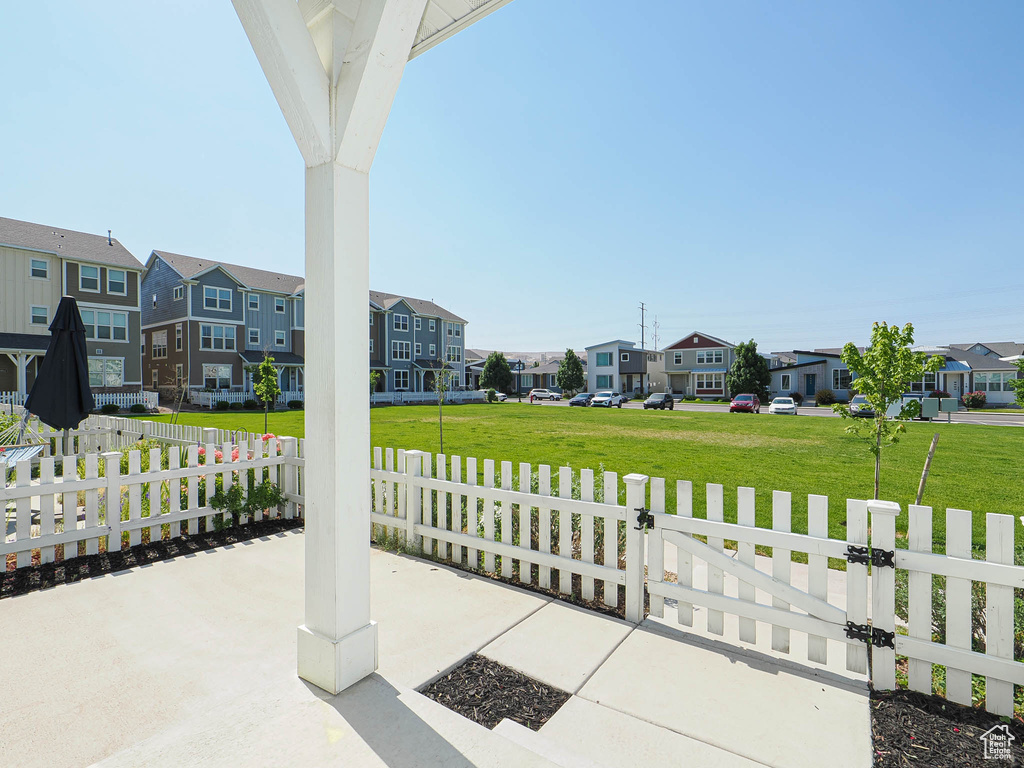 View of patio with a residential view, a fenced front yard, and a gate
