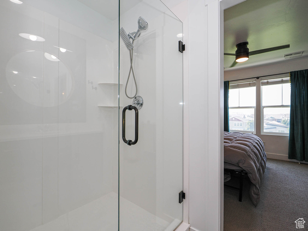 Full bath with connected bathroom, a shower stall, and a ceiling fan