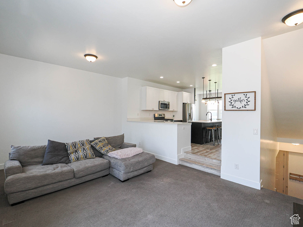 Living area featuring dark carpet and recessed lighting