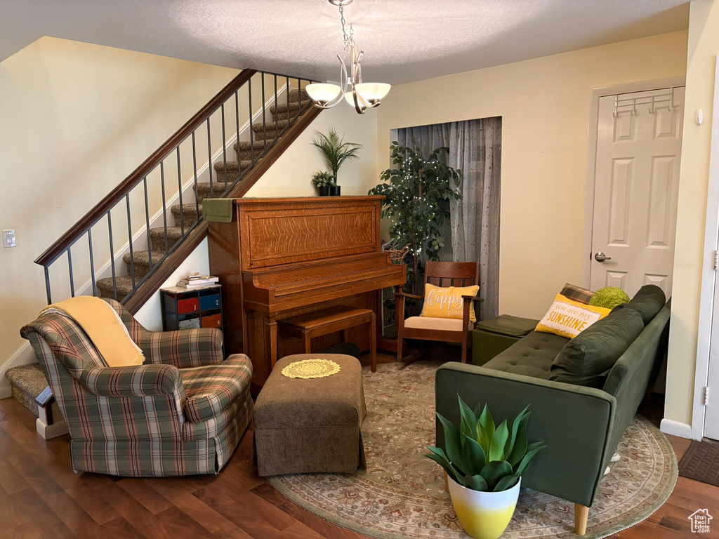 Living area featuring wood finished floors, stairs, and a chandelier
