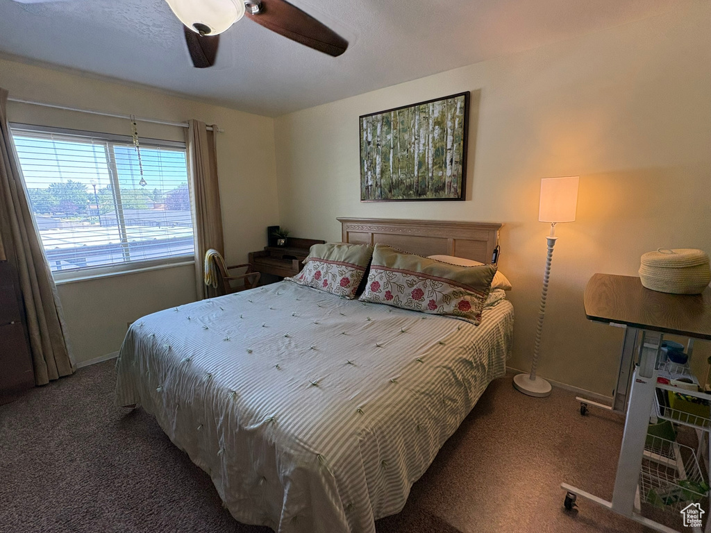 Carpeted bedroom with baseboards and a ceiling fan