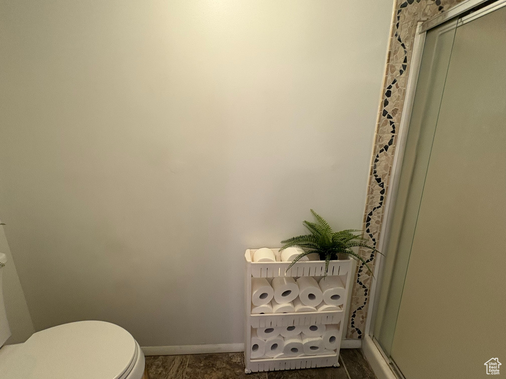 Full bath featuring toilet and a shower