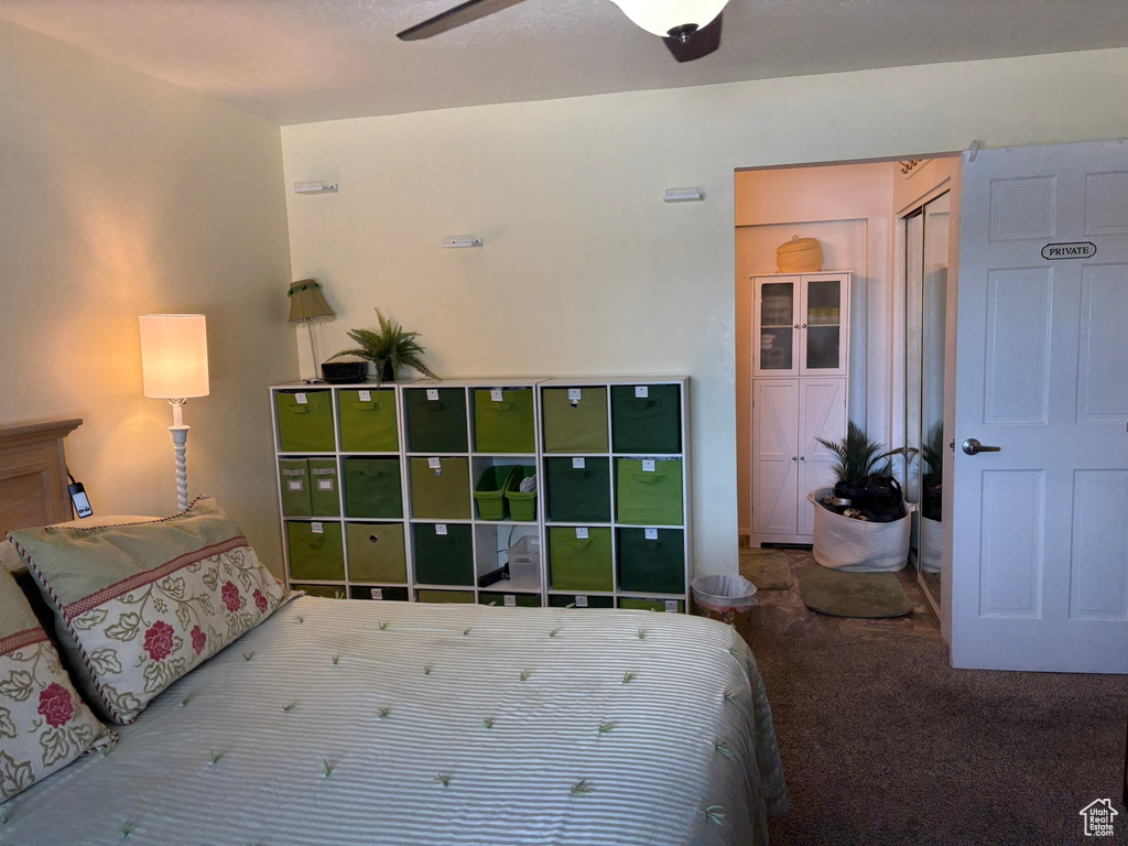 Carpeted bedroom featuring ceiling fan