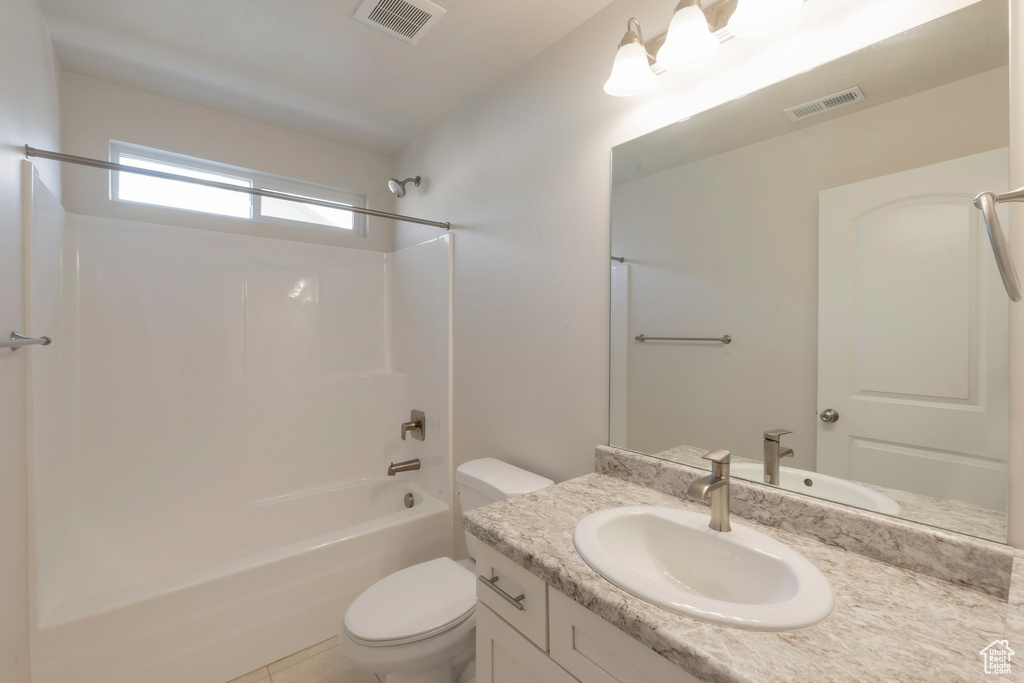 Bathroom featuring toilet, vanity, and shower / washtub combination
