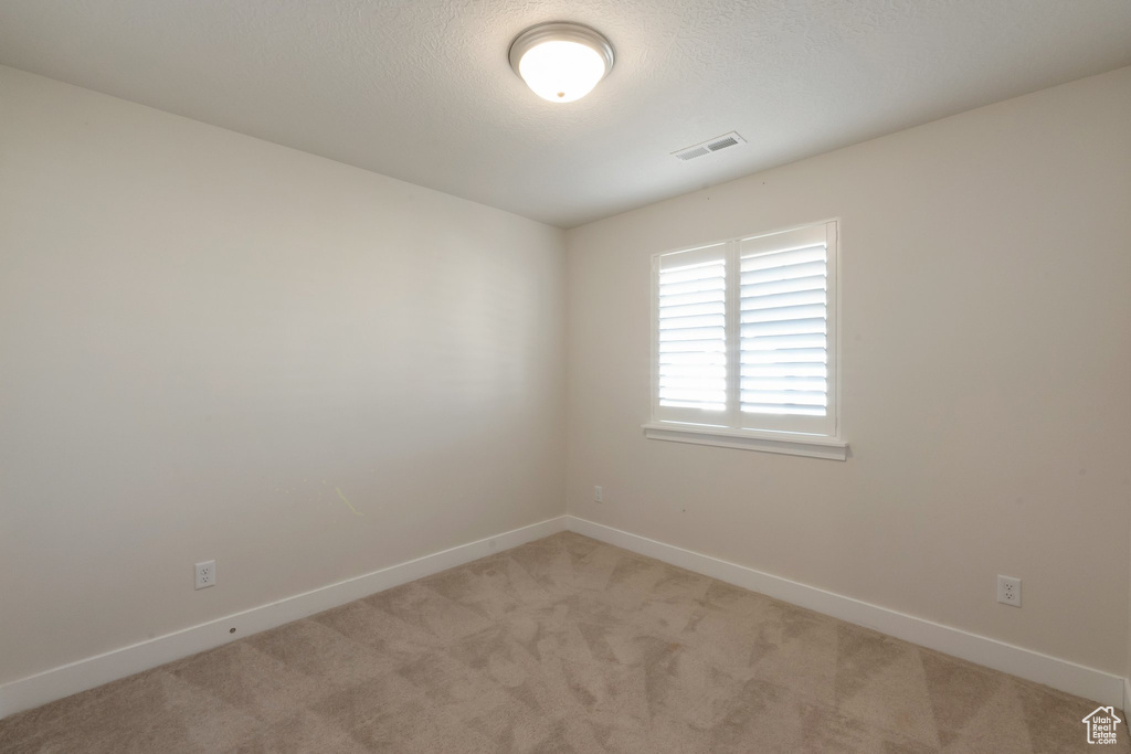 Empty room with light carpet and baseboards