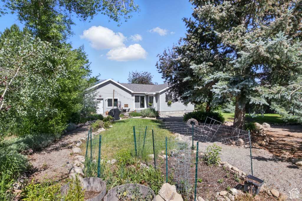 View of front of house featuring a garden and a front yard