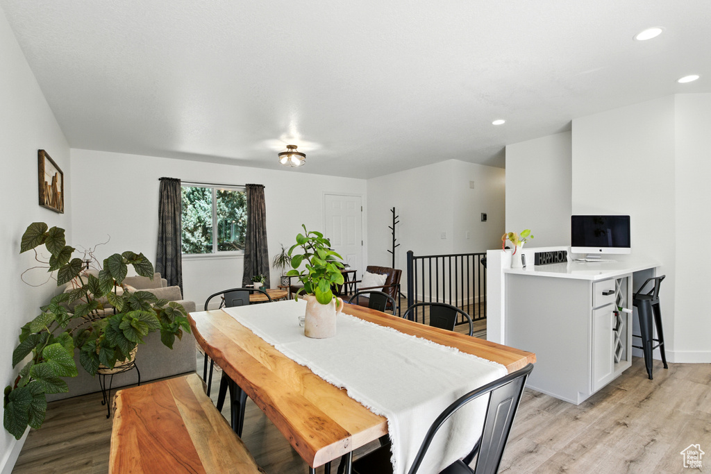 Dining space with light wood-style floors and recessed lighting
